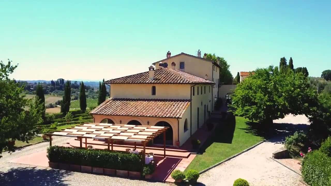 vista dall'esterno della villa leonardo da vinci a casale di valle, immersa nelle verdi colline toscane e circondata da verdi cipressi.